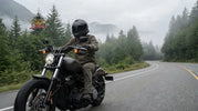 Motorcycle rider using helmet speakers while riding a cruiser on a Pacific Northwest highway