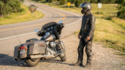 Experienced motorcycle rider wearing practical, functional biker gear at a roadside stop