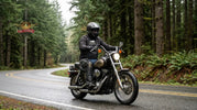 Cruiser rider wearing leather motorcycle chaps riding through the Pacific Northwest on an overcast day