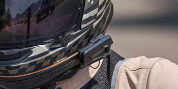 Cardo Bluetooth communicator mounted on a full-face motorcycle helmet
