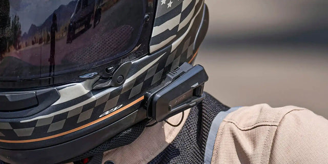 Cardo Bluetooth communicator mounted on a full-face motorcycle helmet