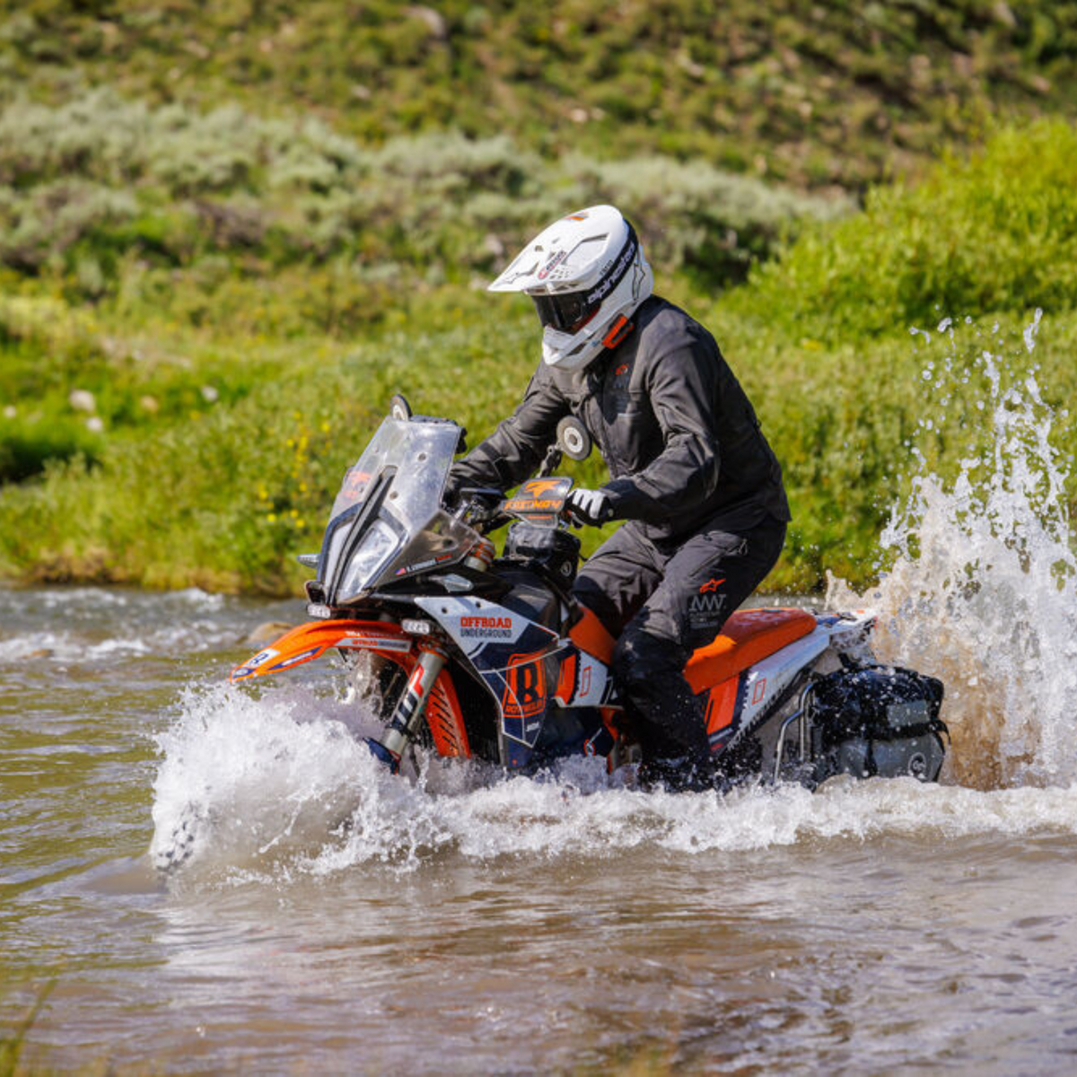 Cardo PACKTALK EDGE KTM orange communicator worn during a water crossing