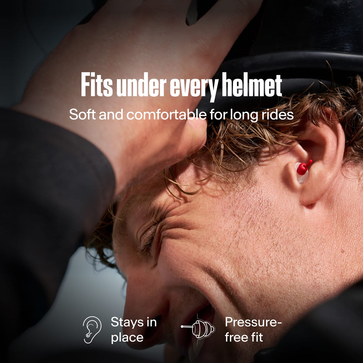 Motorcyclist wearing Alpine MotoSafe Sport earplugs while putting on a helmet