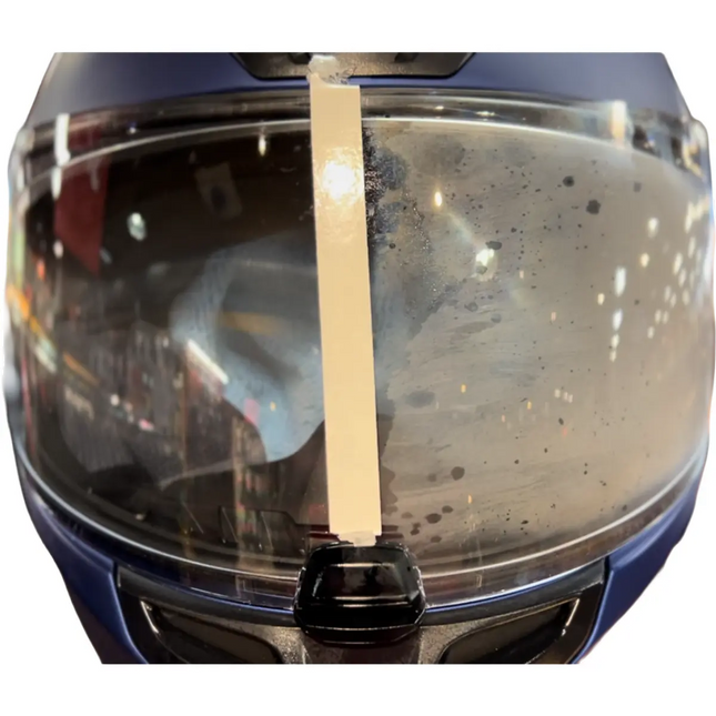 Motorcycle helmet visor showing a clear left side treated with Eagle Leather Anti-Fog Spray and a fogged right side untreated, demonstrating the product’s effectiveness.