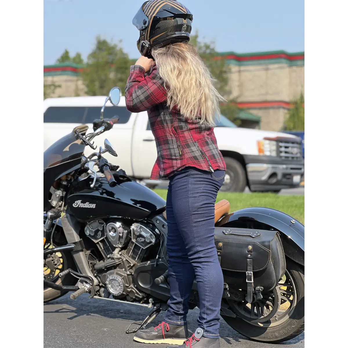 Blue women’s Kevlar motorcycle jeggings beside a motorcycle, side view