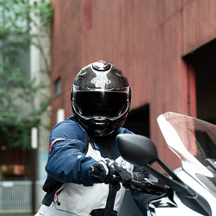 Rider wearing the HJC F100 Carbon helmet on a touring motorcycle