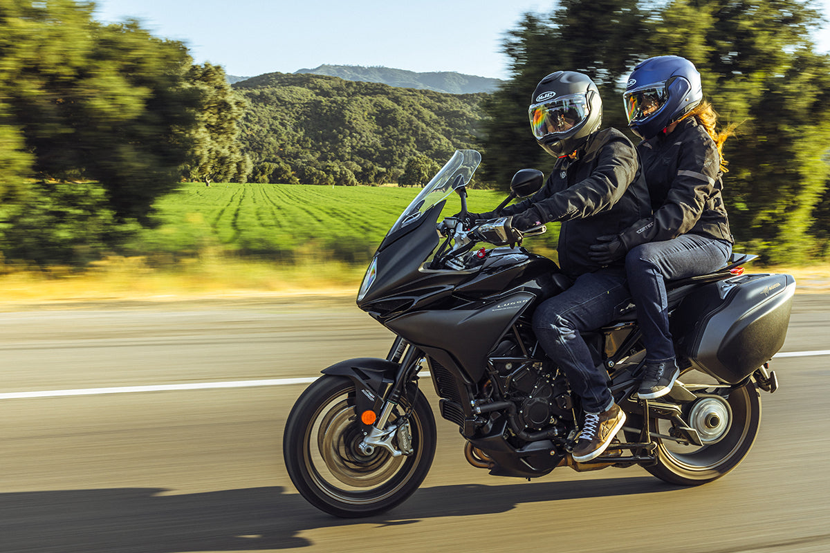 HJC F100 Solid helmets worn by rider and passenger on a touring motorcycle