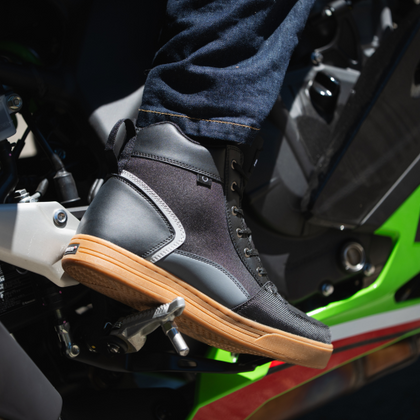 NORU Men’s Tori Boot in black with gum sole positioned on a motorcycle footpeg