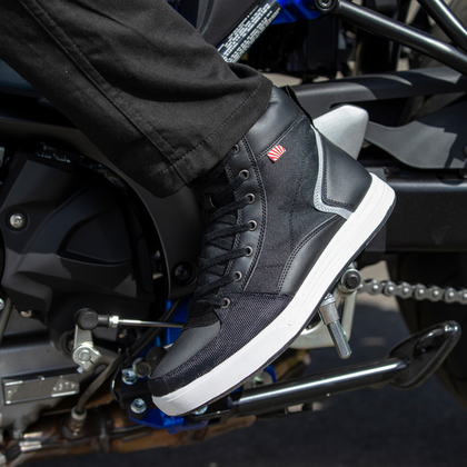 NORU Men’s Tori Boot in black positioned on a motorcycle footpeg