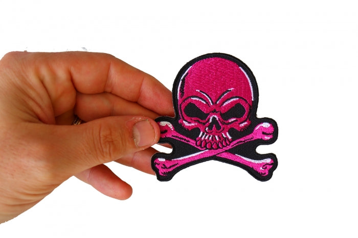 Pink Skull and Crossbones patch shown in hand for size reference