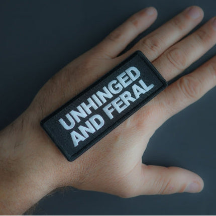 Unhinged and Feral patch shown in hand for size reference