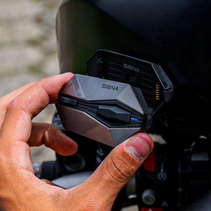Sena 60X communication unit attaching to its magnetic helmet mount