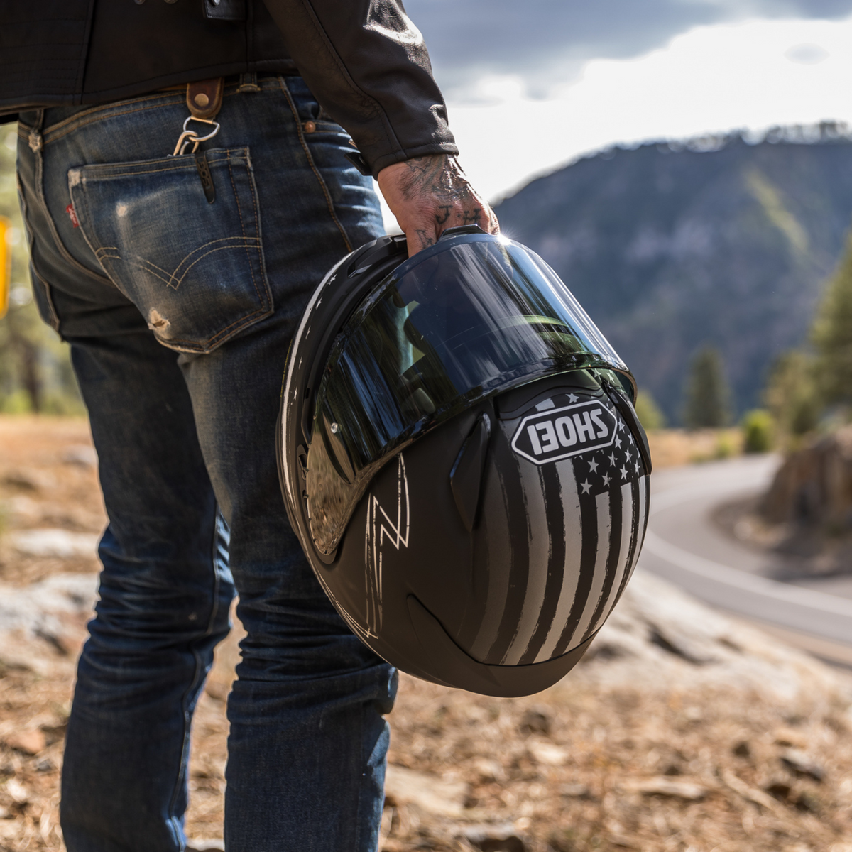 Shoei RF-1400 Dedicated 2 TC-5 matte black and white helmet, rider carrying helmet outdoors