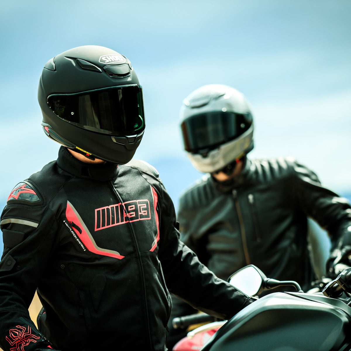 Shoei RF-1400 Solid black and white helmets worn by two riders