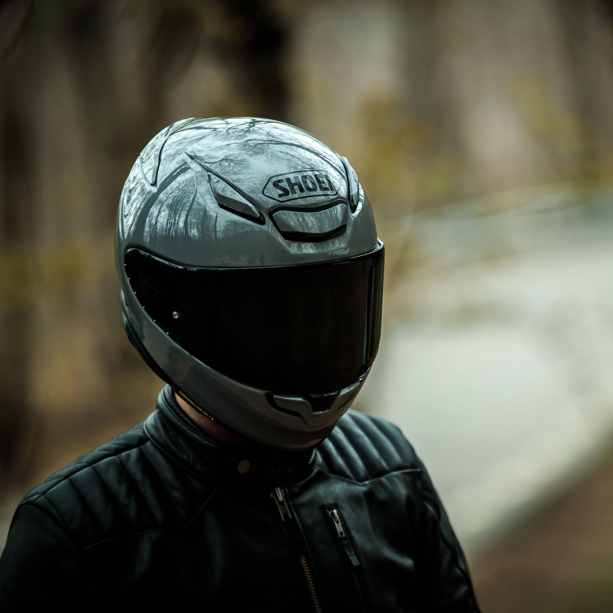 Shoei RF-1400 Solid gloss dark helmet worn outdoors with optional tinted shield
