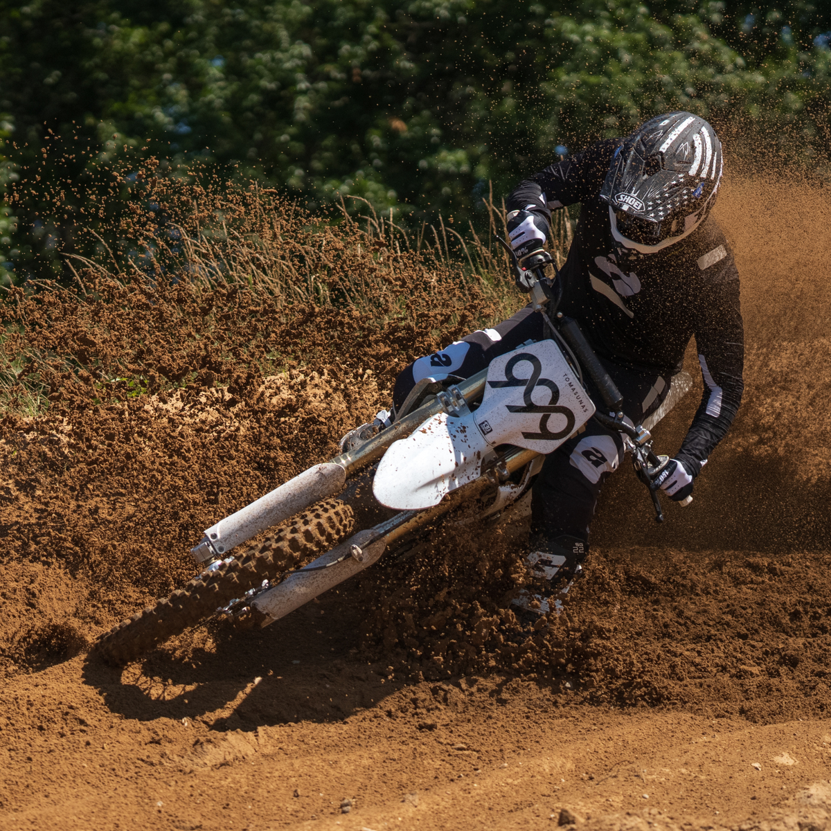 SHOEI VFX-EVO Faithful 2 TC-5 black and white, helmet worn while cornering on a dirt bike