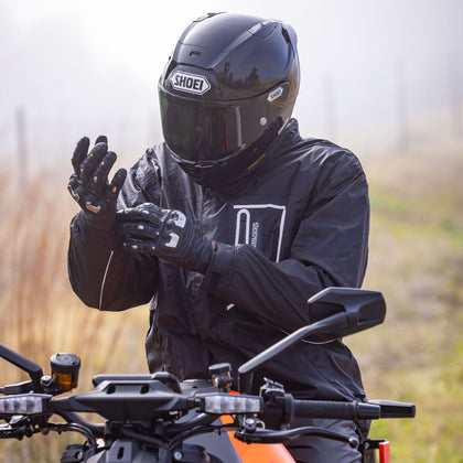 Tourmaster Defender Two-Piece Rainsuit in Black - rider wearing jacket on motorcycle