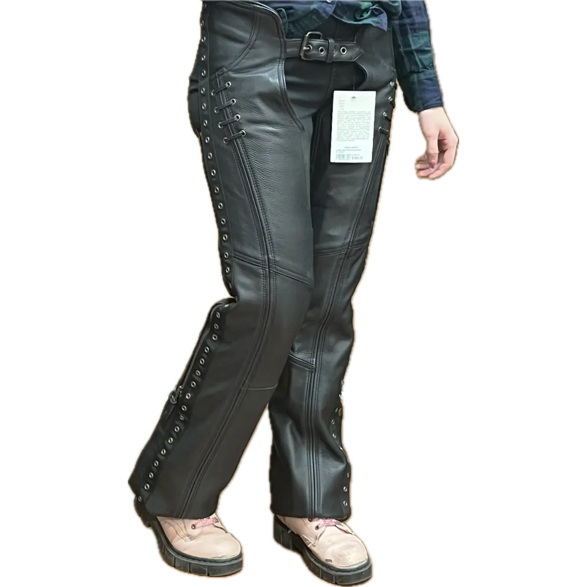 Woman wearing black leather lace-up motorcycle chaps over jeans, shown from a different angle to highlight the fit, detailing, and side lacing.