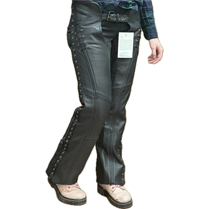 Woman wearing black leather lace-up motorcycle chaps over jeans, shown from a different angle to highlight the fit, detailing, and side lacing.