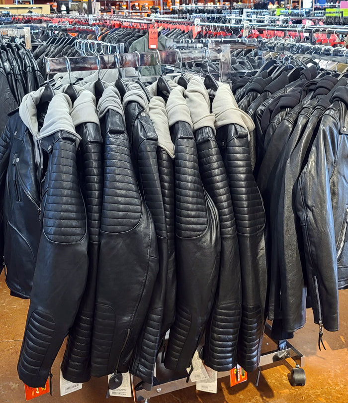 Racks of women's motorcycle jackets on display inside the Eagle Leather store. The jackets include various styles, predominantly black leather with some featuring quilted designs and hooded options.